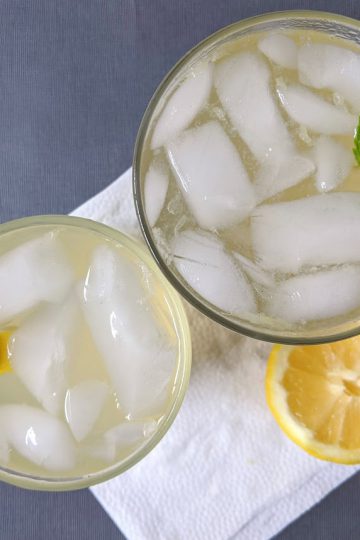 Shikanji glasses viewed from above, with lemon garnish