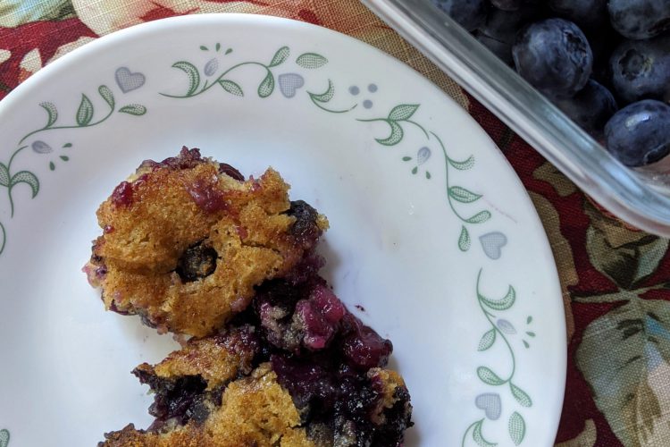 Cobbler served on a plate with blueberries on the side