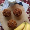 Banana Nut Muffins on cutting board with bananas and milk, bird’s eye view