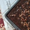 Small Batch Texas Sheet Cake in tray on cooling rack, newspaper in background