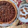 Pecan Pie in tin with plate of pecans, top view