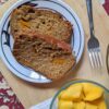 Vegan Mango Bread slices top view with mango bowl on cutting board