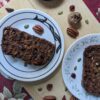 Dried Fruit & Nut Loaf in plates on cutting board with pecans, figs, and cranberries