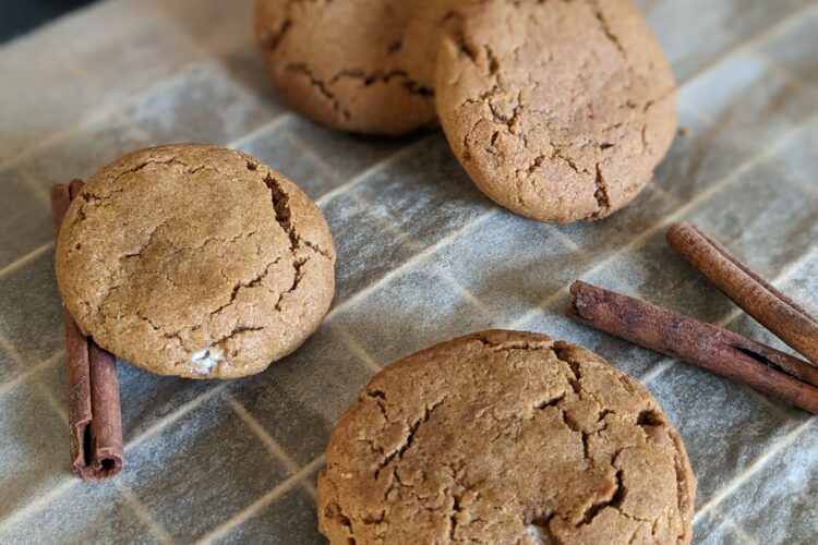 Stuffed pumpkin peanut butter cookies on a cooling rack with a can of pumpkin puree